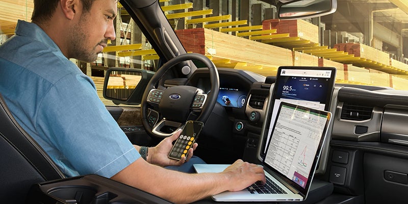 2022 Ford Lightning interior with a man using a mounted laptop