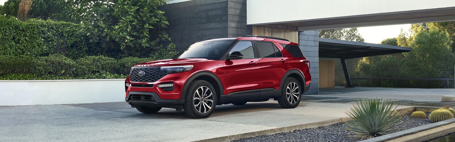 2024 Ford Explorer in red parked in the driveway of a modern home