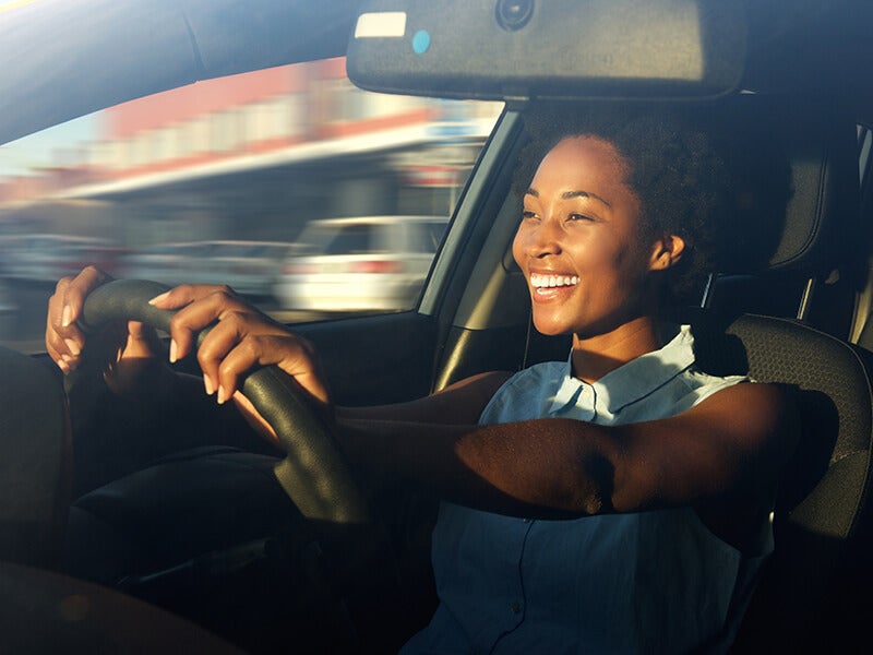 Happy woman driving a car